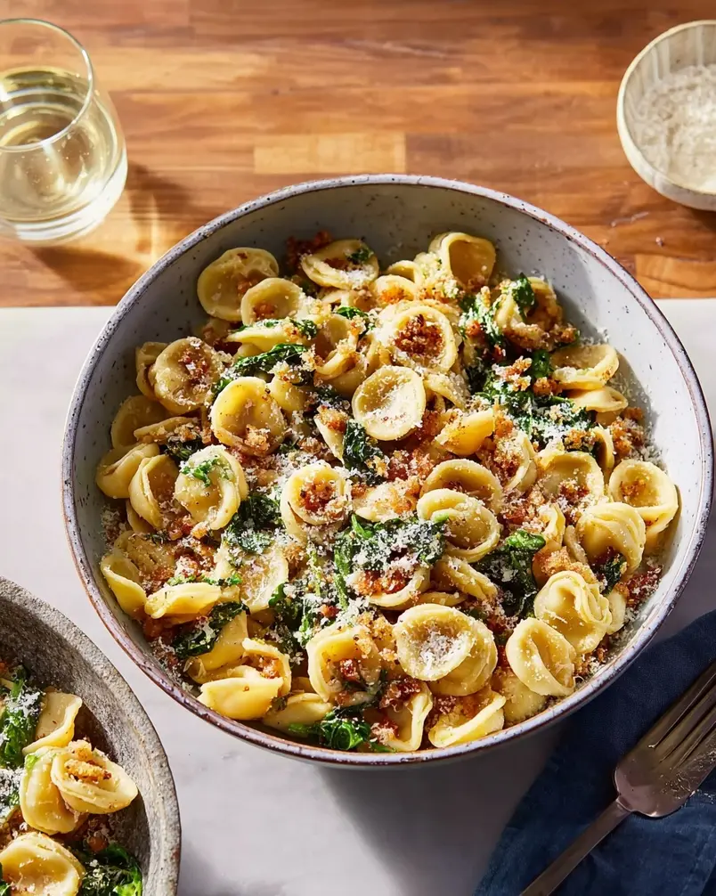 One Pan Orecchiette Pasta 3 A large skillet with orecchiette pasta cooking in broth alongside Italian sausage, onions, and tomatoes.
