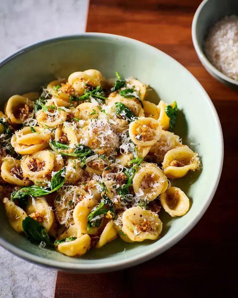 One Pan Orecchiette Pasta 2 Close-up of fresh orecchiette pasta being tossed with vibrant vegetables and sauce in a skillet, ready for cooking.